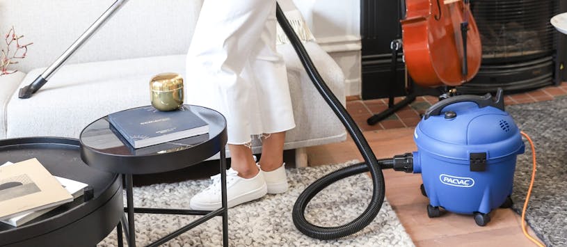 person vacuuming with glide wispa 300 canister vacuum